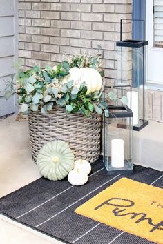 a basket filled with plants sitting on top of a door mat next to a welcome mat