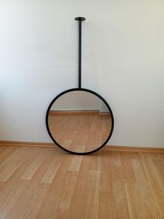 a circular object sitting on top of a hard wood floor next to a white wall