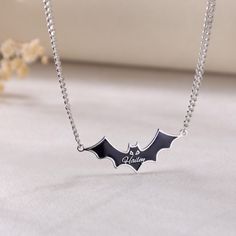 Necklace Details 📿 ------------------------------------------------------ Feature:  Embrace the spookiness of Halloween with our enchanting Custom Black Bat Name Necklace.  Crafted with precision and care, the necklace features a charming black bat pendant made of stainless steel and adorned with enamel work. The combination of stainless steel and enamel gives the pendant a durable yet stylish look. The bat is intricately designed, with fine details that make it truly stand out. It can be enjoyed for many Halloweens to come. What makes this necklace truly special is the custom name option. Personalize it with your own name, a loved one's name, or a special word that holds meaning for you. It's a one-of-a-kind piece that is sure to become a treasured keepsake. Whether you're looking for a Black Themed Necklace For Halloween, Halloween Themed Black Necklace, Themed Black Necklace For Halloween, Halloween Gothic Necklaces With Adjustable Chain, Gothic Halloween Necklaces With Adjustable Chain, Halloween Gothic Necklace With Adjustable Chain, Black Halloween Jewelry With Adjustable Chain, Spooky Black Necklace For Gift, Vampire Style Necklace For Halloween