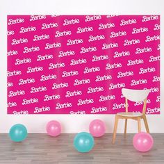 a chair and balloons in front of a wall with the word sparkle on it's side