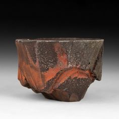 a brown and red vase sitting on top of a table