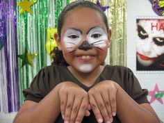 a girl with her face painted like a cat