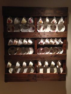 a wooden shelf filled with cups and saucers