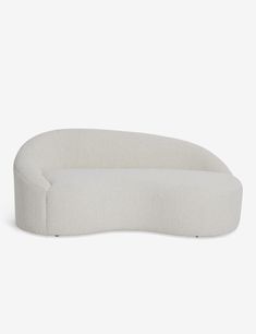 an oval shaped couch sitting on top of a white floor