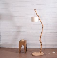 a lamp that is on top of a wooden floor next to a table and chair