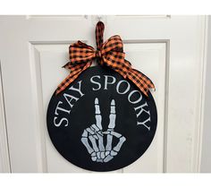 a door hanger that says stay spooky with a hand print on it