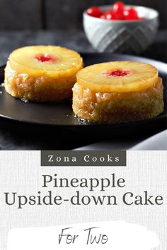 two pineapple upside down cakes on a black plate with cherries in the background