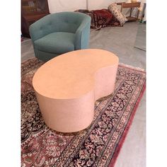 two chairs and a table in a room with rugs on the floor, one is blue