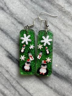 two penguins and snowflakes on green glittery earrings