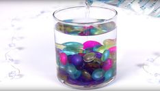 a glass filled with lots of colorful beads