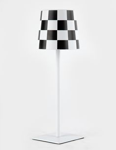 a black and white checkered lamp on a stand