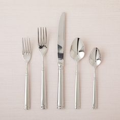 four forks, two spoons and one knife on a white surface