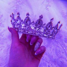 a woman's hand holding up a tiara