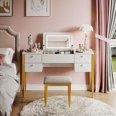 a bedroom with pink walls, white furniture and a rug on the floor in front of it