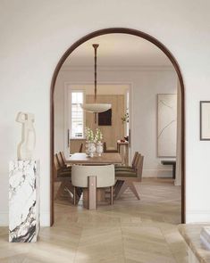 an arch in the middle of a room with a table and chairs on it's side