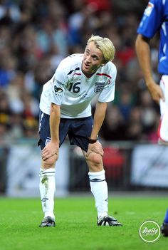 a soccer player is looking down at the ground