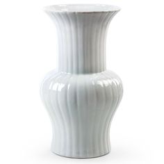 a white vase sitting on top of a table