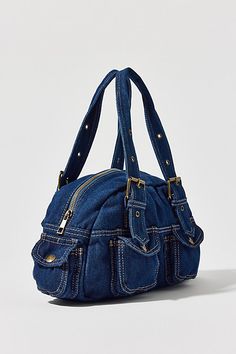 Essential denim bag from BDG with Y2K styling. Duffle style with a zippered top and snapped pouch pockets. Trimmed with a heart-shaped mirror charm and finished with a riveted adjustable shoulder strap. Only at Urban Outfitters. Features BDG denim duffle shoulder bag Denim 2000s bag from BDG Small size bag that fits the everyday essentials Plenty of pockets for storage Zipper closure with an adjustable strap UO exclusive Content + Care 100% Cotton Spot clean Imported Size Dimensions: 12.99" l x Bag Out Of Jeans, 2000s Bags, 2000s Party, Checkbook Covers, Shaped Mirror, Denim Purse, Men's Shoes Accessories, Girly Bags, Fancy Bags