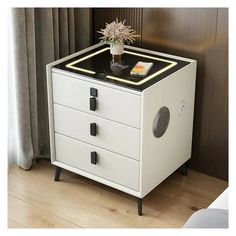 a white and black cabinet with a plant on top