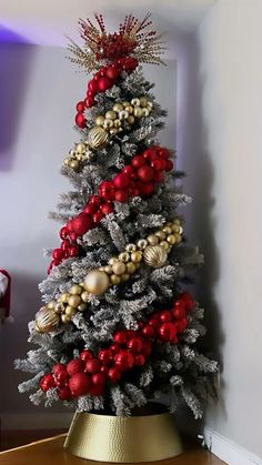 a christmas tree decorated with red, gold and silver ornaments