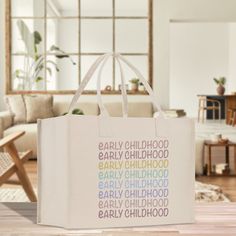 a shopping bag sitting on top of a wooden floor in front of a couch and table