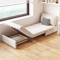 a white couch sitting under a window next to a wooden floor