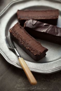 two pieces of chocolate cake on a plate with a fork