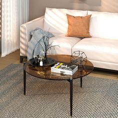 a white couch sitting next to a table on top of a rug