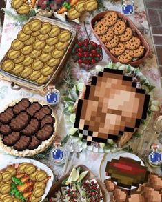 a table topped with lots of cakes and desserts covered in pixel art style food