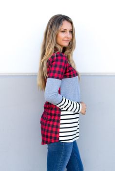 Introducing the Buffalo Plaid Colorblock Tunic, a must-have addition to your wardrobe! This top combines the classic charm of plaid with trendy stripes, offering a unique look that's perfect for any occasion. Whether you're going for a casual vibe with denim and boots or dressing it up with black skinny jeans and heels, this tunic is sure to turn heads. Crafted with the finest materials, this tunic is both comfortable and stylish. The colorblock design adds a touch of sophistication, while the l Striped Color Block Tops For Winter, Casual Plaid Tops For Layering, Striped Cotton Tops With Contrast Color, Cotton Striped Top With Contrast Color, Plaid Patchwork Tops For Fall, Red Tops With Contrast Stripes For Winter, Winter Red Tops With Contrast Stripes, Striped Tops For Layering In Fall, Striped Cotton Tops With Patchwork