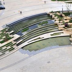 an aerial view of a water feature in the middle of a plaza with people walking around it