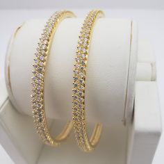 "* Handcrafted Gold Plated 2 Bangle Set. Sold as a set. * Bangles with pretty white CZ stones * High Quality 22 K Gold Plated- 2 Bangle set *2.4 inches= ( 2.25\" diameter of the inner circle) ; 2.6 inches = ( 2.42\" diameter of the inner circle); 2.8inches = (2.54\" diameter of the inner circle) Gorgeous gold-plated bangle/ bracelet best exemplifies the careful craftsmanship done on it -- a specialty at Nemali Jewelry. It has a special tone of elegance attached to it. The intricate handmade desi Gold Plated Round Bangle For Wedding, White Bangle Jewelry For Marriage, White Bangle For Marriage, Dazzling Hoop Jewelry For Wedding, Gold Plated Stackable Bracelets For Wedding, Gold-plated Stackable Bracelets For Wedding, Hoop Bangle For Wedding, Wedding Gold Plated Stackable Bracelets, Stackable Cubic Zirconia Wedding Bangle