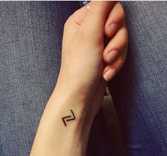 a woman's arm with a small tattoo on the left side of her wrist