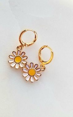 "*Dainty, fun and charming daisy charm huggie hoop earrings! Awesome 90s style throwback! *Layer with other hoops/earrings or wear on its own. *White, yellow and gold enamel daisy flower charm gold plated over zinc alloy- nickel free and lead free *18k gold plated 12mm leverback huggie hoops *Please remove when showering, swimming, sleeping, sweating, etc to preserve the shine and color of the charms! *Quality, small batch, unique, chic Please check out shop policies or message me about question Cute Gold Flower Charm Earrings, Cute Adjustable Huggie Earrings, Cute Gold Summer Jewelry, Cute Nickel-free Hoop Jewelry, Cute Gold Huggie Jewelry, Cute Hypoallergenic Hoop Earrings, Cute Gold Huggie Earrings, Gold Daisy Earrings With Flower Charm, Cute White Huggie Jewelry