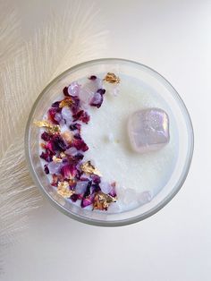 a bowl filled with flowers and ice cubes on top of a white tablecloth