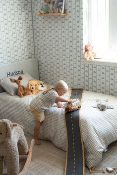 a young boy is playing with toys in his bedroom