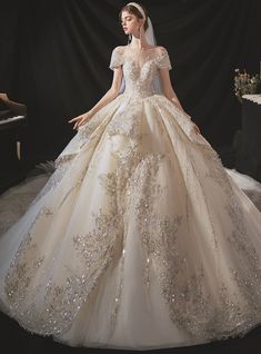 a woman in a wedding dress standing next to a piano