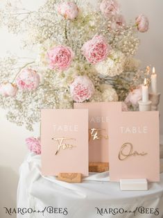 two place cards with the word table to be placed on top of each other in front of a bouquet of flowers