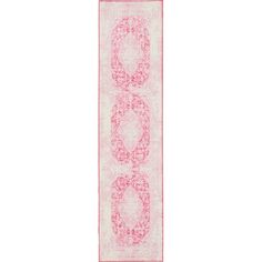 a pink and white runner rug with an oval design on the bottom, in front of a