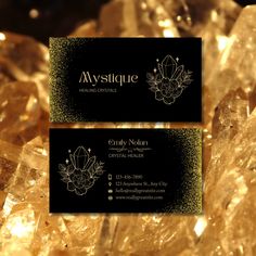 two business cards sitting on top of some crystal rocks in front of gold glitters