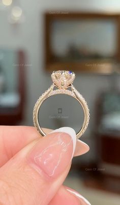 a person holding a diamond ring in their hand