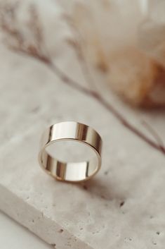 a gold wedding ring sitting on top of a marble slab