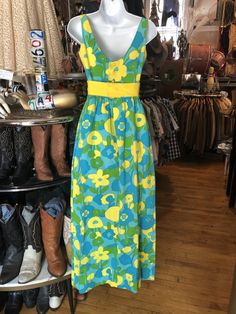 "Vintage Long Sleeveless Dress with Floral Yellow, Green and Teal Cotton Blend Dress Measurements 14\" Arm Opening 32\" Bust 24\" Waist 48\" Length in Back In good used condition. See all photos." Retro Fitted Sleeveless Sundress, Retro Sleeveless Beach Dress, Vintage Sleeveless Beach Sundress, Vintage Sleeveless Sundress For Vacation, Green Sleeveless Lined Maxi Dress, Retro Sleeveless Dress With Vintage Print, Retro Summer Maxi Dress For Daywear, Yellow Sleeveless Lined Maxi Dress, Retro Sleeveless Lined Dress