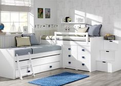 a child's bedroom with white furniture and blue rugs on the wooden floor