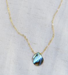 Looking for a unique necklace that captures the essence of the ocean and promotes feelings of peace and beauty? Look no further! Our handcrafted pendant features a teardrop-shaped genuine abalone shell in shades of green, blue, pink, cream, purple, and brown. Available in both sterling silver and 14k gold filled. It's the perfect gift for beach lovers!*The reverse side of the abalone is a tan color and can have natural imperfections along its surface. Pendant Size: average .75 x .5 inches (17x12mm)Modeled Size: 15 inches Adjustable Teardrop Pearl Pendant Jewelry, Turquoise Necklace With Pearl Drop As Gift, Turquoise Necklace With Pearl Drop For Gift, Elegant Abalone Shell Necklace As Gift, Elegant Abalone Shell Necklace For Gift, Handmade Teardrop Abalone Shell Jewelry, Bohemian Teardrop Mother Of Pearl Jewelry, Handmade Teardrop Mother Of Pearl Jewelry, Handmade Pear-shaped Necklace For Gift