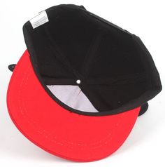 a red and black hat with a white label on the front, sitting against a white background