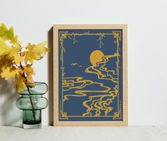 a vase filled with yellow flowers next to a framed art print on a white wall