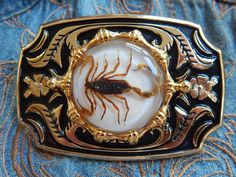 .                We are a small independent company based in Derbyshire.We source our materials/parts Worldwide  and then handcraft /assemble our items in our workshop to create something a little different High Quality solid gold coloured metal large belt buckle size 9cm x 6cm will fit up to a 40mm wide belt Genuine Scorpion set in  resin white background very detailed. We make these up to order and every one is different and unique so will vary from image  We will refund you £5 if you purchase one of our leather belts together with this buckle Goth Belt Buckle, Outlaw Outfit, Western Goth, Large Belt, Goth Wedding, Metal Belt, Leather Work, Suspender Belt, Wide Belt