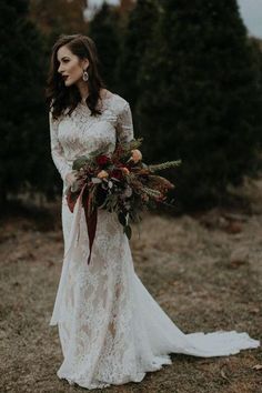 a woman in a wedding dress holding a bouquet and looking at the camera with her hand on her hip