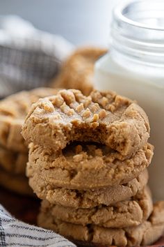 three cookies stacked on top of each other next to a glass of milk